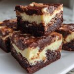 Four rich, layered squares of brownie refrigerator cake featuring dark chocolate and creamy cheesecake layers.