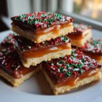 A stack of delicious Caramel Ritz Cracker Christmas Cookies topped with chocolate and festive sprinkles.