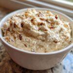 A close-up of creamy, homemade onion dip topped with caramelized onions served in a white bowl.
