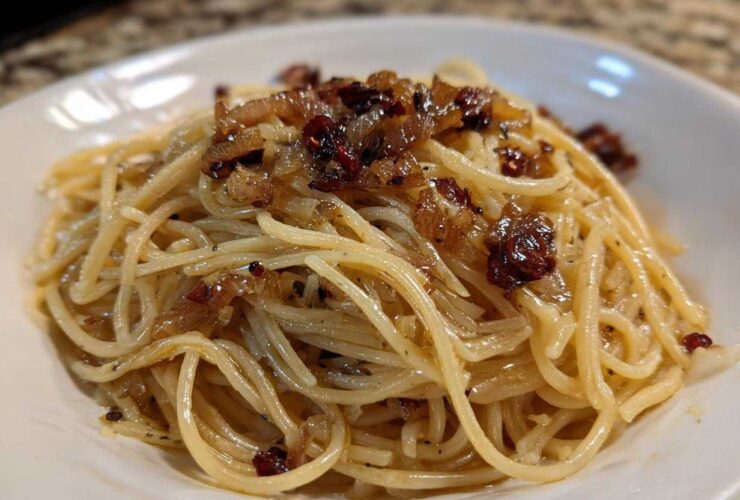 Close-up of creamy caramelized onion pasta tossed with spaghetti noodles and topped with rich, dark caramelized onions.