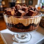 Close-up of a glass trifle bowl filled with layers of chocolate cake, cream, and topped with chocolate cake cubes for the Baileys Chocolate Cheesecake Trifle.