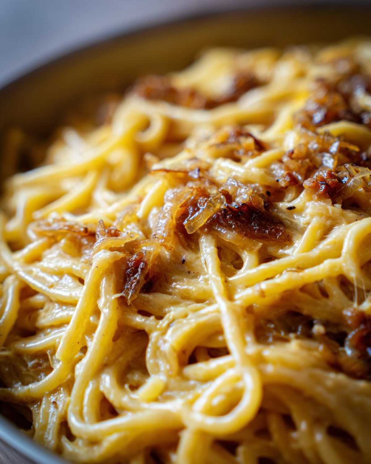 Close-up of creamy french onion pasta coated in sauce and topped with rich, caramelized onions.