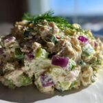 A generous scoop of healthy tuna salad mixed with diced red onion and celery, topped with fresh dill.