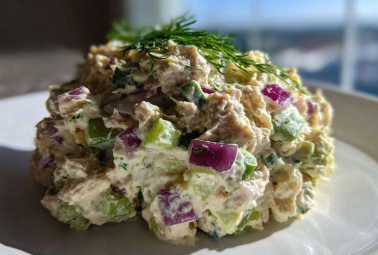A generous scoop of healthy tuna salad mixed with diced red onion and celery, topped with fresh dill.
