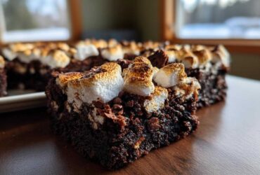 Close-up of a fudgy hot chocolate brownie slice topped with toasted marshmallows.