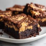 Close-up of a fudgy peanut butter swirl brownies square showing the dark chocolate base and creamy peanut butter topping swirl.