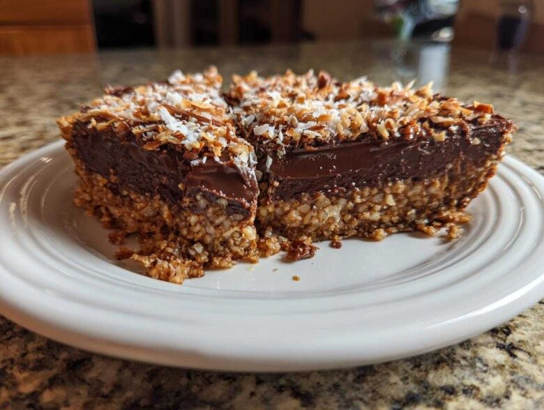 A rich slice of German chocolate pie showing a thick chocolate layer and a coconut-pecan crust, topped with toasted coconut.