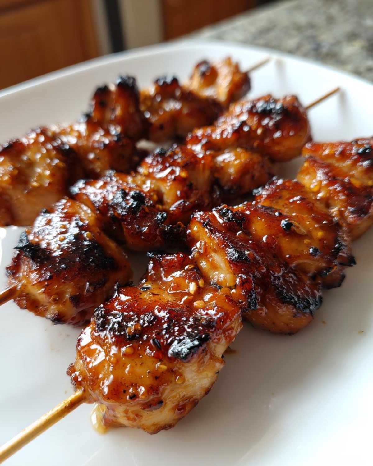 Close-up of several grilled honey garlic chicken skewers with a sticky, caramelized glaze.