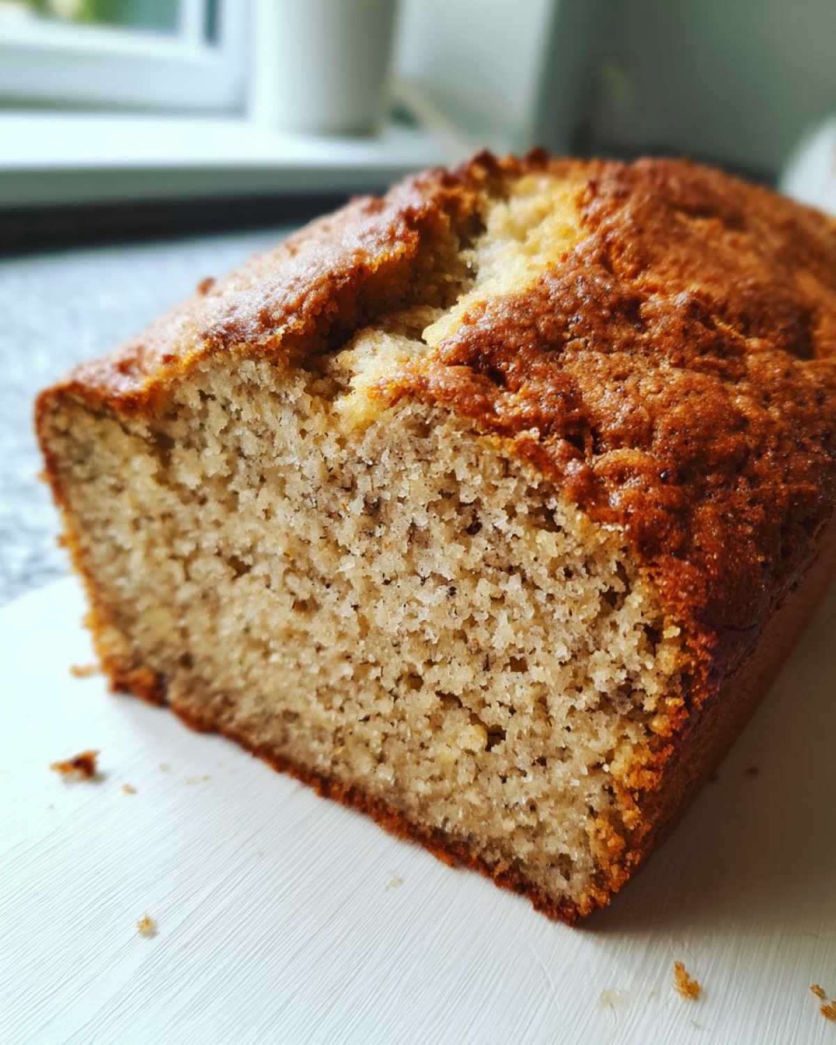 Close-up of a freshly baked loaf of greek yogurt banana bread showing its moist, tender crumb and golden-brown crust.