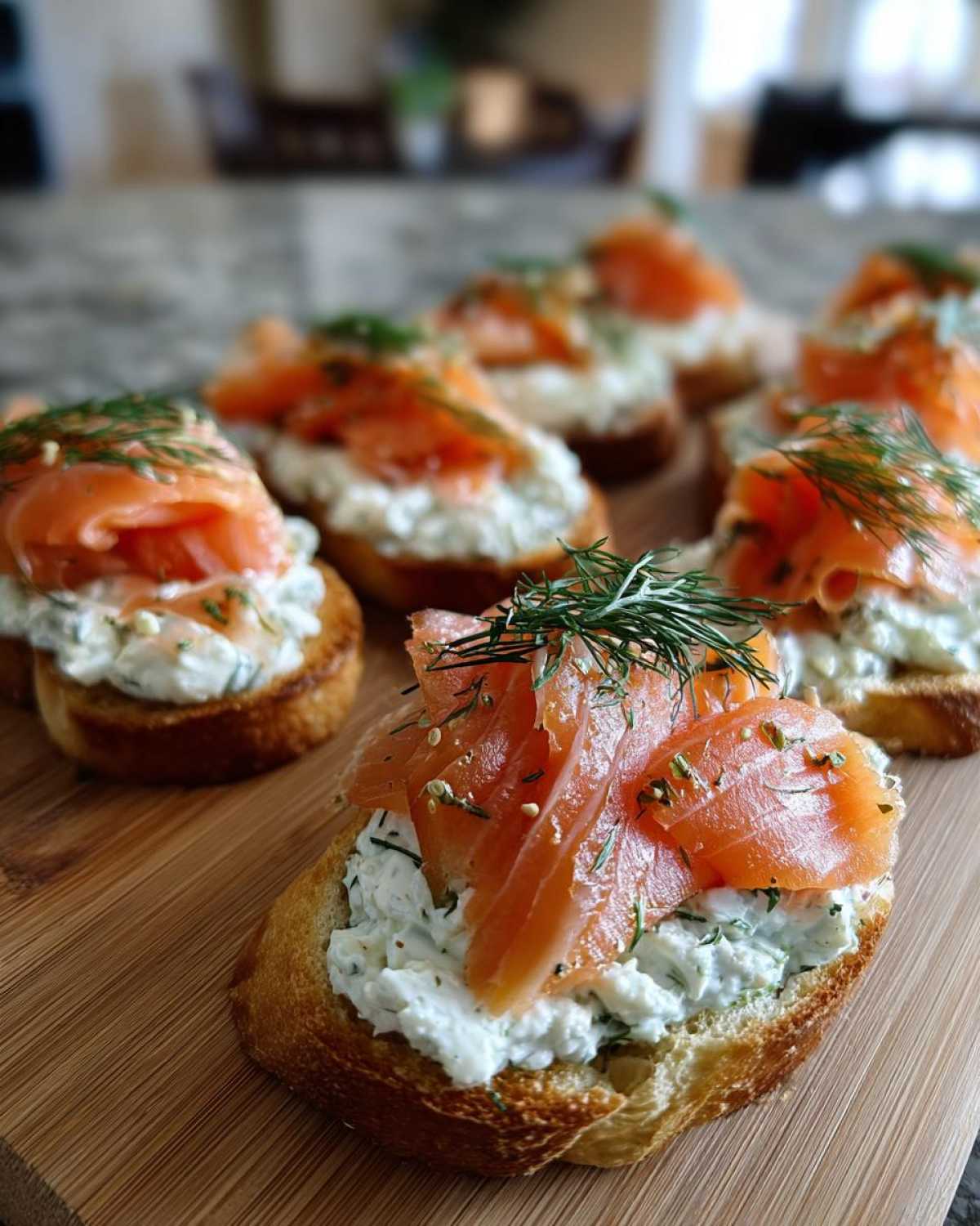 Close-up of delicious smoked salmon bites served on toasted bread with cream cheese spread and fresh dill garnish.