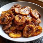 Close-up of crispy, golden brown Air Fryer Crispy Cinnamon Sugar Banana Chips coated in sugar.