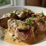 Close-up of seared One-Pan Creamy Garlic Butter Pork Tenderloin Medallions covered in sauce and parsley.