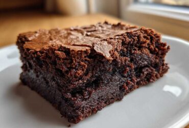 Close-up of a rich, fudgy slice of gingerbread brownies showing a crackly top.