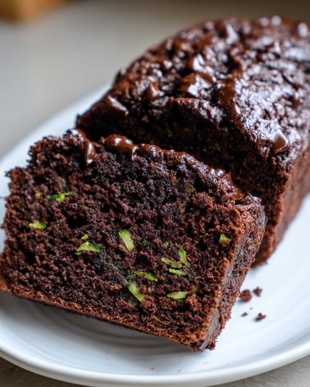 Close-up of rich, moist Gluten-Free Chocolate Zucchini Bread with visible green zucchini shreds.