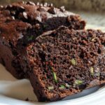 Close-up of moist Gluten-Free Chocolate Zucchini Bread with visible zucchini shreds and chocolate chips.