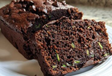 Close-up of moist Gluten-Free Chocolate Zucchini Bread with visible zucchini shreds and chocolate chips.