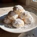 A stack of soft Gluten-Free Lemon Meltaway Cookies heavily dusted with powdered sugar on a white plate.