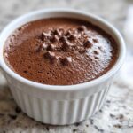 Close-up of rich, airy Keto Creamy Chocolate Cheesecake Mousse served in a white fluted ramekin.
