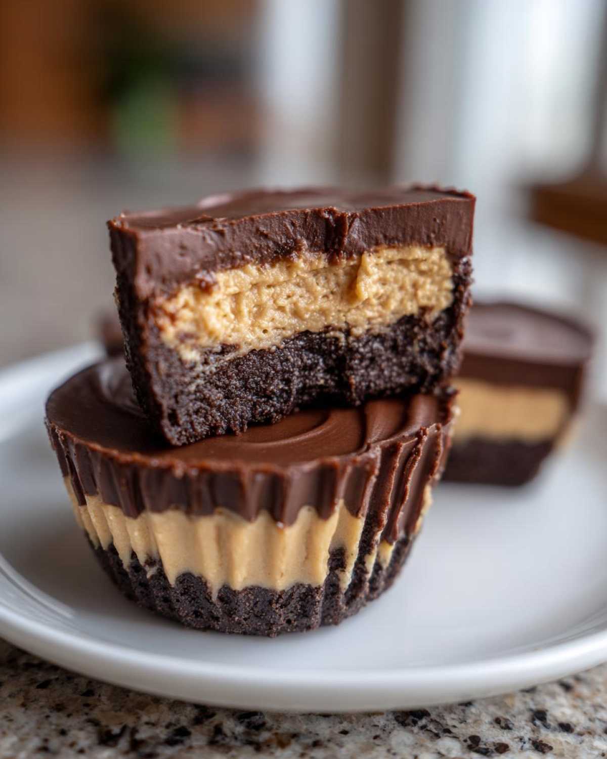 Close-up of a No-Bake Chocolate Peanut Butter Cheesecake Cup cut in half showing layers.