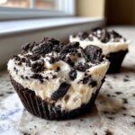 A close-up view of a single No-Bake Cookies and Cream Pie Cup with creamy filling and crushed cookie topping.