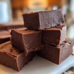 A stack of rich, dark No-Bake Espresso Chocolate Fudge Squares on a white cutting board.