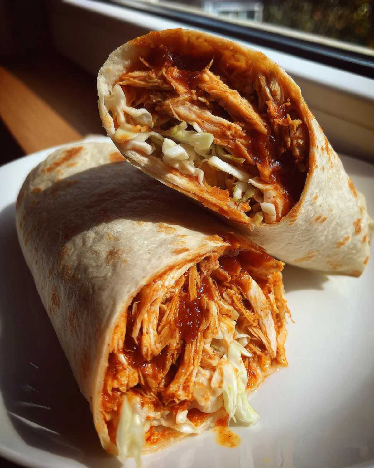 A cross-section of a Bbq Chicken Wraps Flavorful Busy recipe, showing shredded chicken coated in BBQ sauce and crisp shredded lettuce.