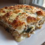 A generous slice of Cheesy Lentil Bake Comfort Food, showing melted cheese and a golden breadcrumb topping.