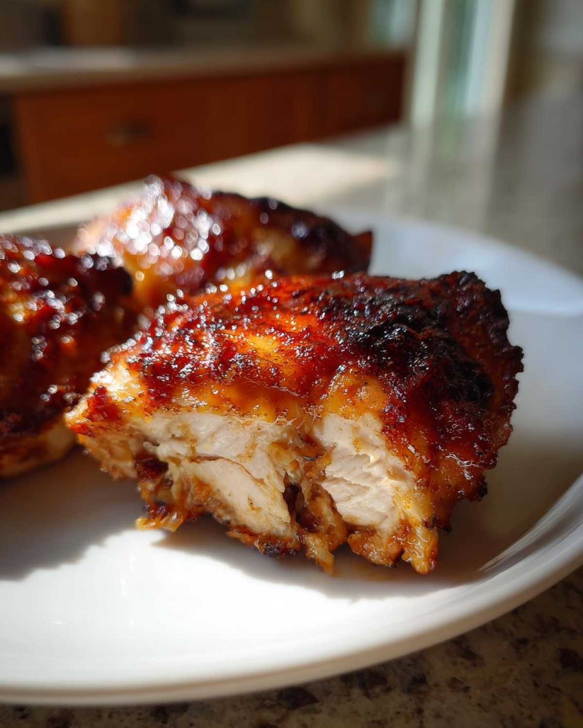 Close-up of a cross-section of juicy Chipotle Honey Chicken Thighs showing the moist interior and caramelized glaze.