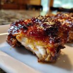 Close-up of a juicy, glazed Chipotle Honey Chicken Thighs piece showing the caramelized, sticky sauce and tender white meat.