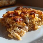 Close-up of a serving of French Onion Chicken Orzo Casserole with a golden-brown, cheesy top.