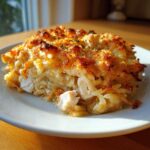 A hearty serving of French Onion Chicken Orzo Casserole showing chunks of chicken and orzo pasta with a golden, crispy cheese topping.
