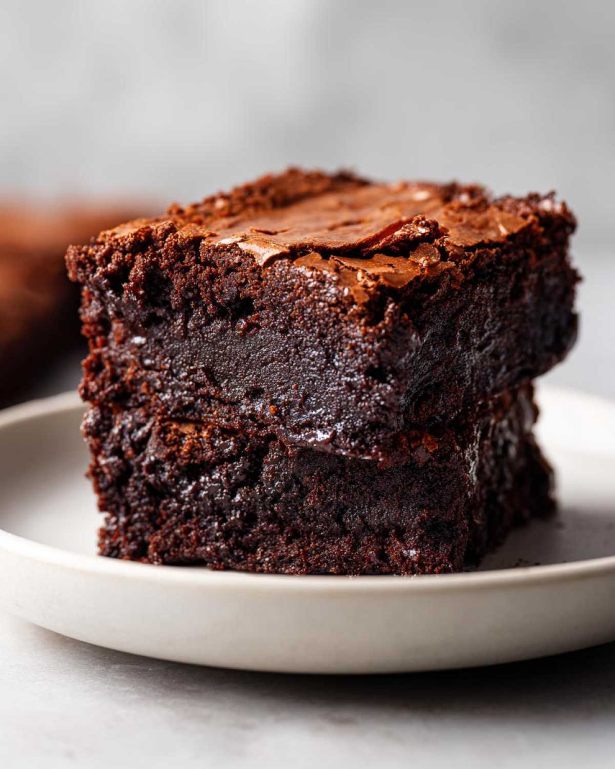 Close-up of two stacked, intensely dark and fudgy brownies missing that fudgy texture problem solved.