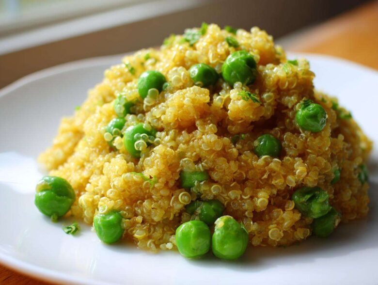 A mound of golden Garlic Butter Quinoa Green Peas garnished with fresh parsley on a white plate.