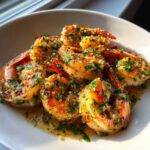 Close-up of succulent Hawaiian Garlic Shrimp coated in a buttery, garlicky sauce and topped with fresh green parsley.