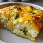 A close-up slice of Low Carb Chicken Casserole featuring shredded chicken, broccoli, and a golden melted cheddar cheese topping.