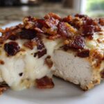 Close-up of Malibu Chicken Cheesy Bacon Chicken showing melted cheese and crispy bacon topping over moist chicken breast.