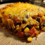 Close-up of a cheesy slice of Southwestern Black Bean Casserole showing black beans, corn, and melted cheese.