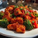 Close-up of Sweet Spicy Thai Chicken pieces coated in a glossy sauce with bright green broccoli florets.