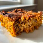 Close-up of a serving of Whole30 BBQ Chicken Casserole showing the orange sweet potato base mixed with shredded chicken.