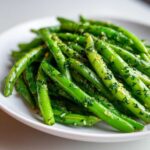 Close-up of bright green beans tossed with herbs and garlic, a component for Greek Bean Salad.