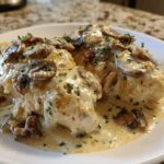 Two pieces of Creamy Smothered Chicken covered in a rich mushroom cream sauce and garnished with parsley.