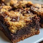 A close-up, featured image of a fudgy, layered Brookies bar showing the dark brownie base and the lighter cookie topping with melted chocolate chips.