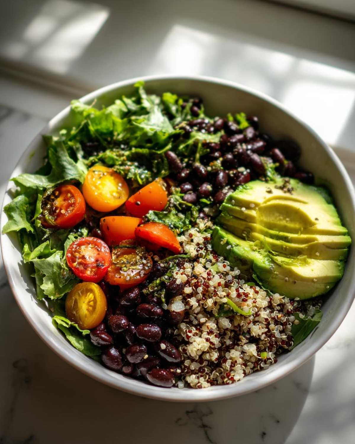 Close-up of a Fresh Avocado Bowl featuring sliced avocado, black beans, quinoa, and cherry tomatoes.