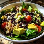 Close-up of a vibrant Fresh Avocado Bowl featuring avocado chunks, black beans, quinoa, cherry tomatoes, and lettuce.