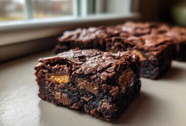 A close-up of a rich, fudgy Kit Kat Brownies square showing melted candy pieces baked inside.