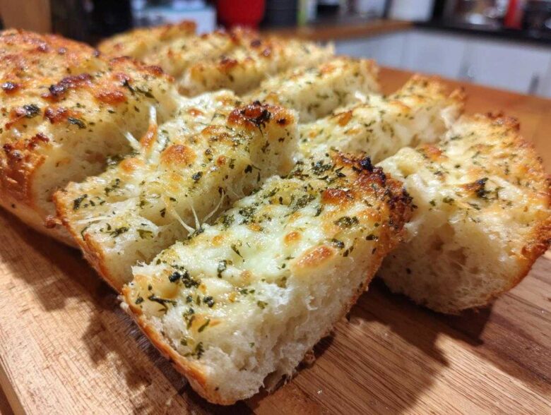 Close-up of freshly baked Garlic Bread with Cheese, showing melted cheese and herbs on sliced bread.