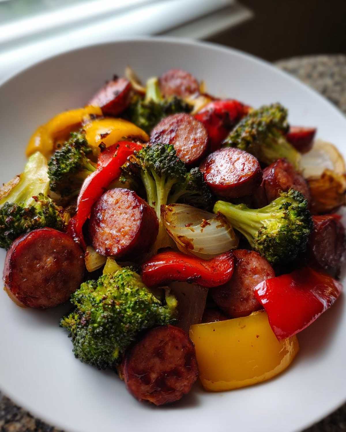 A close-up of Honey Garlic Kielbasa & Veggies, featuring browned sausage slices, bright broccoli florets, and colorful bell peppers.