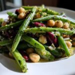 Close-up of bright green beans, chickpeas, and kidney beans tossed in a Lemon Basil Three Bean Salad dressing.