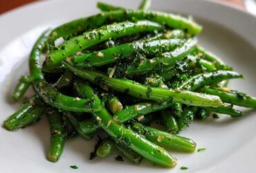 Close-up of bright green beans tossed in a savory herb dressing, part of the Greek Bean Salad recipe.