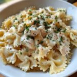 A close-up, appetizing shot of Creamy Chicken Bowtie Pasta tossed in a rich white sauce and garnished with parsley.